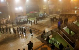 Riot police stand on guard after passengers angry over delays in evening commuter rail service, throw stones as they clashed with riot police at the Constitucion train station