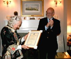 While applauded by His Excellency the Governor, Merle Hunter-Christie reads her Certificate of Honour, recognising four decades of work on behalf of the Falklands