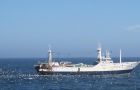 A trawler is followed by seabirds while discarding fish offal