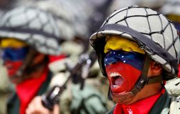 Troops painted with the national colours march along the streets of Caracas 