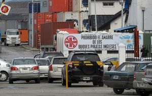  A view of the entrance to the cargo section of the Argentinian port of Ushuaia, with a sign that reads; English pirate ships are prohibited from mooring.
