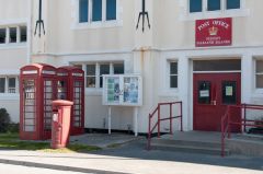Red telephone booths and red mail boxes with monograms of Queen Elizabeth II, who besides greets you at every public office