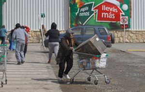 Looters loaded with electronic appliances flee from the supermarket