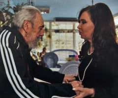 The Argentine president holds hands with the ailing Fidel Castro