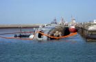 ARA Santisima Trinidad on her side next to the pier in Puerto Belgrano