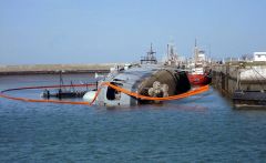 ARA Santisima Trinidad on her side next to the pier in Puerto Belgrano