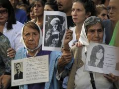 Members of the Human Rights organization Madres de Plaza de Mayo Linea Fundadora and other demonstrators hold portraits of people who went missing in the 1976-1983 military dictatorship (AFP)