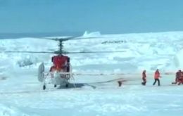 The Snow Dragon helicopter lands next to Akademic Shokalskiy to pick up the passengers 