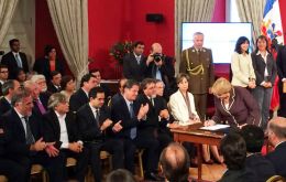 The Chilean president signs the bill, the center piece of her electoral campaign 