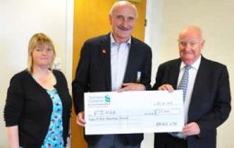 Overseas Games Association Chairman Mike Summers receives a cheque from Argos Ltd Directors Sheila Stewart and Ian Thomson