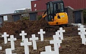 Some of the pictures show the removed graves and a small excavator at the cemetery