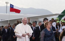 Francis was greeted by President Michelle Bachelet and a band played while the two walked on a red carpet as night began to fall. 