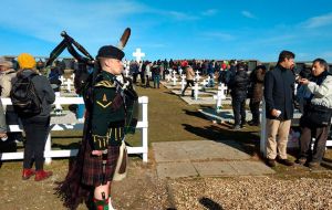 Scots Guards members played bagpipes against a backdrop of vast, grassy plains, and some relatives collected stones to bring back to the mainland
