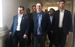 A photo posted by his office showed Bolsonaro smiling as he walked down a corridor with officials in tow.