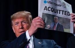 Trump made his feelings clear by holding up a copy of USA Today with another banner headline proclaiming his acquittal.