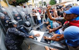 Opposition protesters face the police that block their march in Caracas on Tuesday. (AP Photo / Ariana Cubillos)