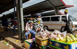 A woman and her daughter wearing face masks to protect against coronavirus, sell fruit and vegetables at the taxi station in Lenasia, south of Johannesburg, South Africa. AP PHOTO/THEMBA HADEBE
