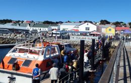 Cruise tourists landing in Stanley pier during a busy sunny summer day