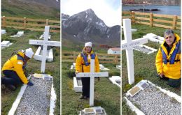 Artuso children and ex members of submarine ARA Santa Fe honor his grave covered with an Argentine flag at Grytviken cemetery 