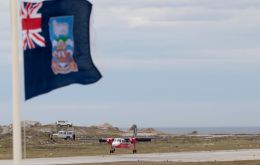 A FIGAS Islander landing kith a Falklands flag flying