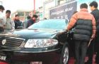 Chinese consumers looks at a new sedan launched in the local market
