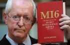 Professor Keith Jeffery poses for photographers with his book “MI6 The History of the Secret Intelligence Service 1909-1949