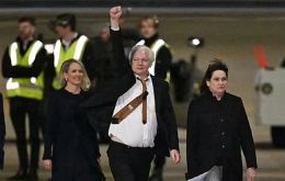 Assange, 52, deplaned from the executive jet in a dark suit, white shirt, and tie, and with his fist in the air