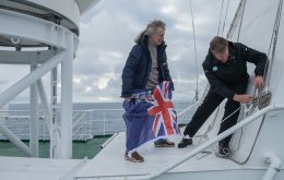 Mensun Bound, Director of Exploration and Simon Frederick Lighthelm, Ice pilot of the expedition raise the Falklands flag on the SA Angulhas II.