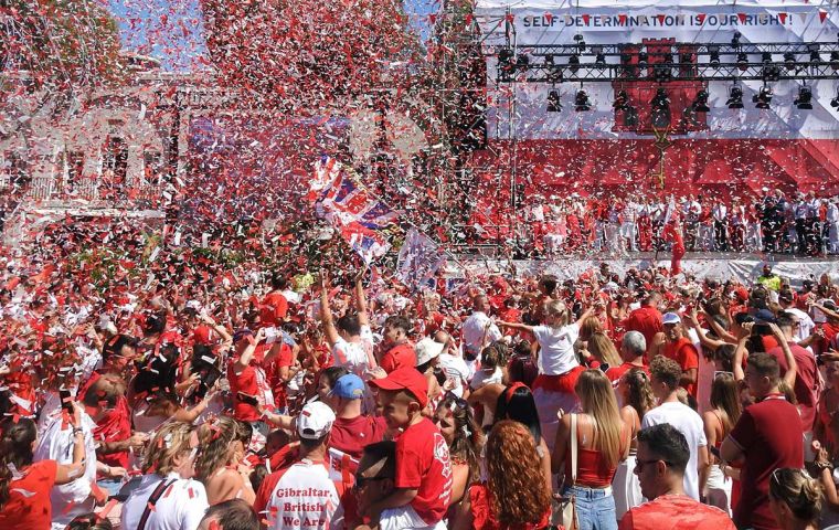 On a warm sunny day, Gibraltarians in traditional Rock colors of red and white assembled at noon for some short political addresses and to sing the National Anthem