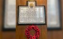 A poppy wreath hangs from the memorial tablet of those lost on November first 1914 from HMS Good Hope and HMS Monmouth.