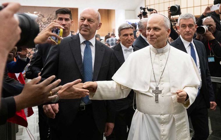 Pope Leo XIV walks down to greet journalists at a meeting in the Paul VI audience hall ten days ago 2025.