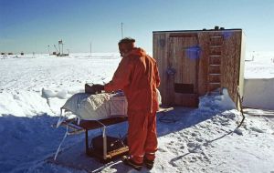 Scientist Joe Shanklin in outdoor clothing, using Dobson spectrophotometer outside, Halley, 22 Jan 1982.