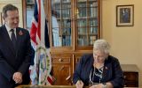 Gov. Colin Martin-Reynolds and Returning Officer Dr Andrea Clausen sign papers to dissolve the Legislative Assembly and confirm December 11 as the date for the General Election 