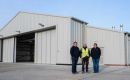 M. Wallbank (Managing Director), G. Vatamanu (General Foreman) and Natasha Greenland (General Manager), Adderstone Co. (Falkland Islands) Ltd, outside the newly completed FIGAS hangar, Port Stanley.