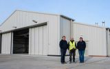 M. Wallbank (Managing Director), G. Vatamanu (General Foreman) and Natasha Greenland (General Manager), Adderstone Co. (Falkland Islands) Ltd, outside the newly completed FIGAS hangar, Port Stanley.