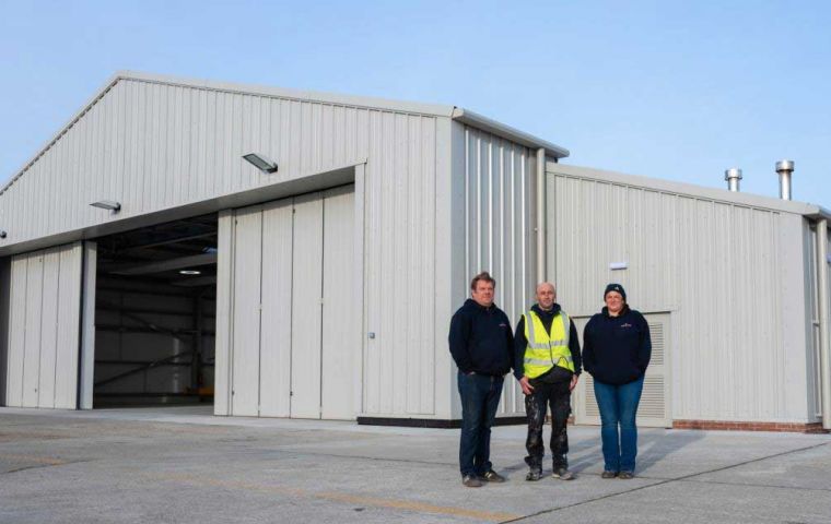 M. Wallbank (Managing Director), G. Vatamanu (General Foreman) and Natasha Greenland (General Manager), Adderstone Co. (Falkland Islands) Ltd, outside the newly completed FIGAS hangar, Port Stanley.