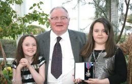 David Lang CMG CBE proudly shows off his honour with granddaughters Louise and Vicky Williams