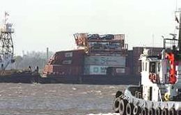 The barge loaded with containers and cages with cars