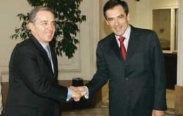 Pte. Alvaro Uribe, left, greets French PM Francois Fillon
