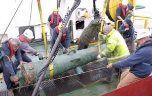 A bronze cannon known as a 42-pounder, is lifted from the sea