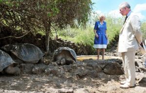 Britain's Prince Charles and his wife, the Duchess of Cornwall, Camilla Parker Bowles, walk next to a giant turtle during a visit to the Charles Darwin Research Station. Photo: AFP