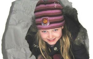 Lucianne Henry peers out from an igloo built in her garden in the week the Falklands became a winter wonderland.  Photo A. Henry