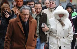 People with scarves and hoods seek protection from the freezing gusts in Montevideo 