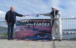 The two activists raise a banner at the roof of the hotel “Hafnia” in front of the parliament of Faroe (WDSF/ProWal)