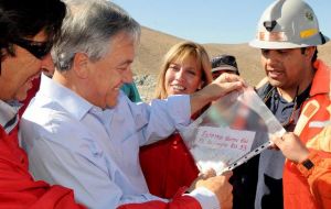 President Piñera shows the cameras the written message from the trapped miners