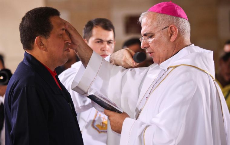 Priest Mario Moronta, right, makes a cross sign on Venezuela's President Hugo Chavez's forehead during a mass for Chavez's recovery in Caracas
