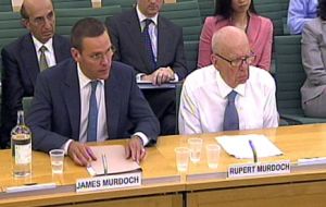 James and Rupert Murdoch testifying at the committee 