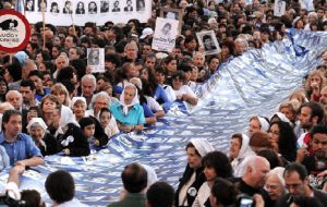 Thousands of marchers spread a 600 metres banner with the Argentine colours during the march through Buenos Aires 