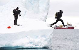 Taking the plunge: A navy diver leaps from an iceberg near the Antarctic Peninsula, while a colleague looks on (Photo: Arron Hoare/MoD)