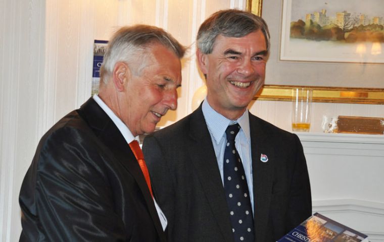 Patrick Watts MBE gives a copy of his book to Falklands Governor Mr. Nigel Haywood CVO